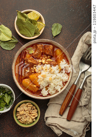 Delicious massaman curry with beef, potatoes, rice, and peanuts is served in bowl top view, Thai cuisine Delicious massaman curry with beef, potatoes, rice, and peanuts is served in bowl top view, Thai cuisine 119803447