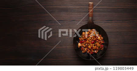 Traditional Chinese dish kung pao chicken in wok pan on wooden background top view 119803449