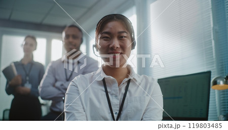 Asian female technical customer support specialist in headset looking at camera 119803485
