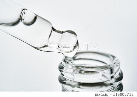 Close-up of a cosmetic bottle with a pipette showing the texture of the serum. 119803715