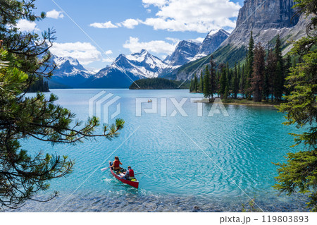 People canoeing on Maligne Lake near the spirit island. Snow-capped mountains and turquoise lakes scenery in Jasper National Park, Alberta, Canada. Canadian Rockies. People canoeing on Maligne Lake near the spirit island. Snow-capped mountains and turquoise lakes scenery in Jasper National Park, Alberta, Canada. Canadian Rockies. 119803893