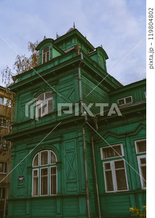 A green, wooden, old building of unusual shape 119804802