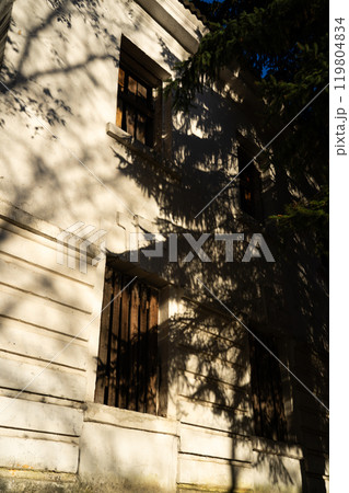 Boarded-up windows of an old abandoned building. Evening sunlight 119804834