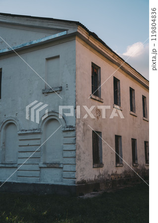 Boarded-up windows of an old abandoned building. Evening sunlight 119804836