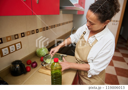 Woman preparing fresh salad in modern kitchen setting Woman preparing fresh salad in modern kitchen setting 119806013
