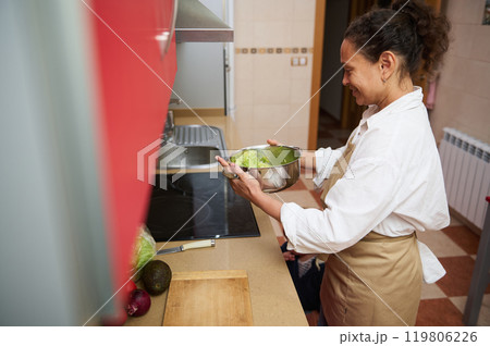 Woman preparing fresh salad in modern kitchen at home Woman preparing fresh salad in modern kitchen at home 119806226