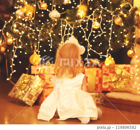 happy child dreams near christmas tree with gifts boxes at home 119806582