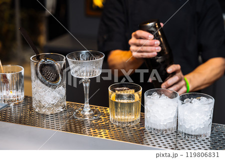Crafting cocktails and tasting fine spirits at a bar during a lively evening 119806831