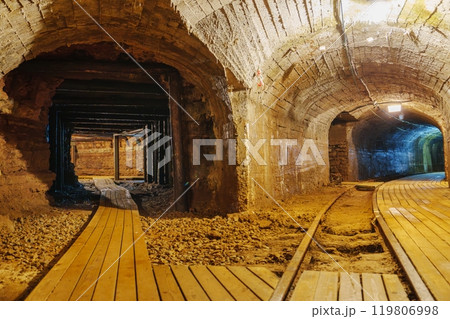 Exploring The Enigmatic Old Abandoned Mine Tunnel Featuring A Wooden Walkway And Rusty Tracks Exploring The Enigmatic Old Abandoned Mine Tunnel Featuring A Wooden Walkway And Rusty Tracks 119806998