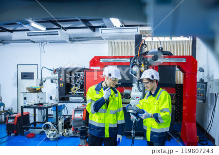 Technician engineer using remote control automation robotics at industrial modern lab factory. Team technological researching and developing working at factory innovation automation robot. Technician engineer using remote control automation robotics at industrial modern lab factory. Team technological researching and developing working at factory innovation automation robot. 119807243