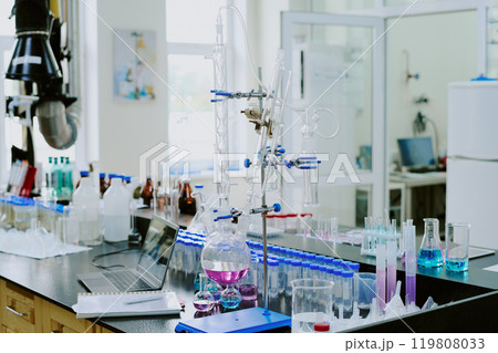 Laboratory showcasing modern chemistry equipment with various glass apparatus setup for experiments featuring colored liquids adding vibrancy to workspace 119808033