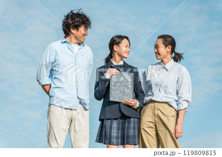 青空の下で卒業証書を持つ笑顔の娘と両親・ファミリー 青空の下で卒業証書を持つ笑顔の娘と両親・ファミリー 119809815