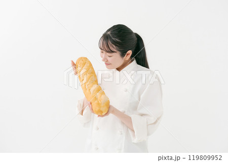 フランスパンを持つ女性料理人のポートレート フランスパンを持つ女性料理人のポートレート 119809952