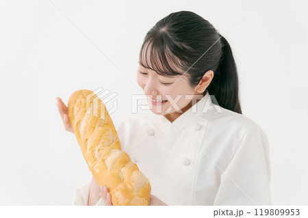 フランスパンを持つ女性料理人のポートレート フランスパンを持つ女性料理人のポートレート 119809953