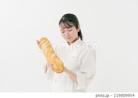 フランスパンを持つ女性料理人のポートレート フランスパンを持つ女性料理人のポートレート 119809954