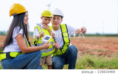 man and a child are looking at a device while a woman looks on man and a child are looking at a device while a woman looks on 119810469