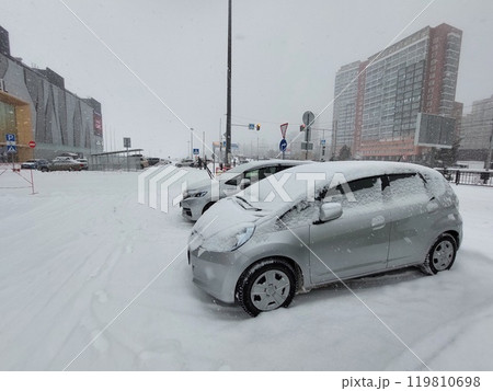 Cars parked in the snow near a shopping mall 119810698