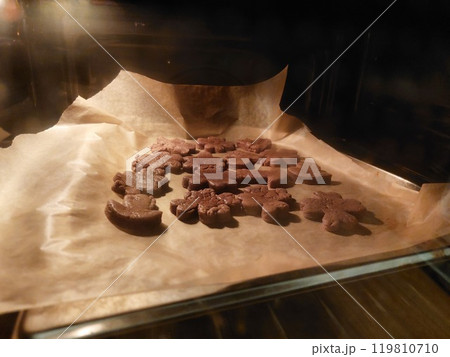 Homemade cookies on a piece of paper in the oven Homemade cookies on a piece of paper in the oven 119810710