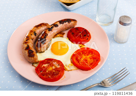 Breakfast from sunny-side-up eggs with sausages and tomatoes 119811436