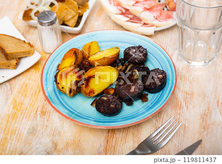 fried black pudding with crispy crust,garnished with baked potatoes in their skins fried black pudding with crispy crust,garnished with baked potatoes in their skins 119811437