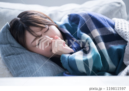 風邪で具合が悪すぎて寝込んでしまう女性のクローズアップ 119811597