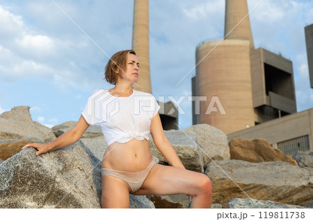 Portrait of slim woman in t-shirt and panties posing on rocky beach 119811738