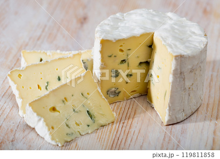 Slices of tasty soft blue cheese with blue mold at wooden board 119811858