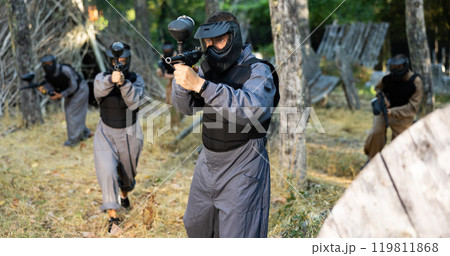 Man shooting with paintball marker outdoors Man shooting with paintball marker outdoors 119811868