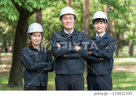 森林の中で腕組みをする林業・土木業の作業着姿の男女の作業員 119812595