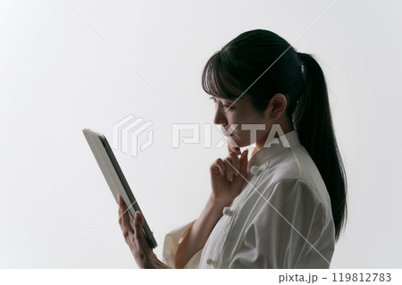タブレットを見て考える女性シェフ タブレットを見て考える女性シェフ 119812783
