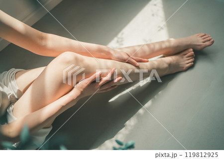 オイルをマッサージしながら足に塗るフットケア 119812925