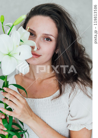 Beautiful Fashionable Slim Brunette Woman with Lily Flowers in White Dress 119813586