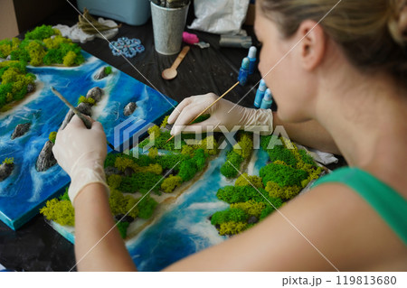 The process of making the art decor of epoxy resin, natural stones and moss 119813680