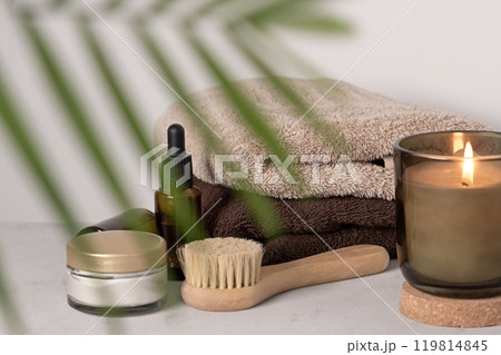 Skin care product for oil face massage and flowers on white table. Eco friendly organic reusable self care accessories. Skin care product for oil face massage and flowers on white table. Eco friendly organic reusable self care accessories. 119814845