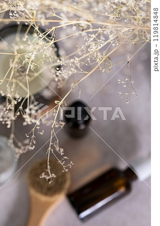Skin care product for oil face massage and flowers on white table. Selective focus. Eco friendly organic reusable self care accessories. 119814848
