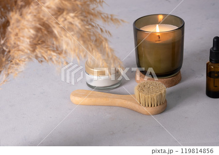 Skin care product for oil face massage and flowers on white table. Eco friendly organic reusable self care accessories. Skin care product for oil face massage and flowers on white table. Eco friendly organic reusable self care accessories. 119814856