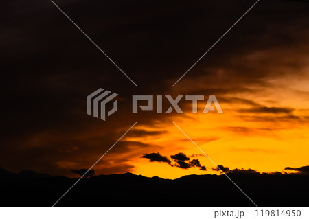 秋の夕空 雲が覆う西の空と山並みのシルエット 高彩度コントラスト 秋の夕空 雲が覆う西の空と山並みのシルエット 高彩度コントラスト 119814950