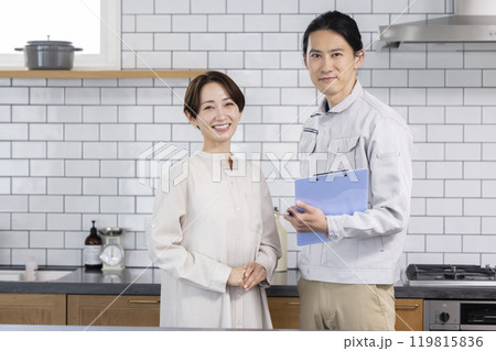 住宅営業　リフォームの相談をする主婦と作業着を着た男性 119815836