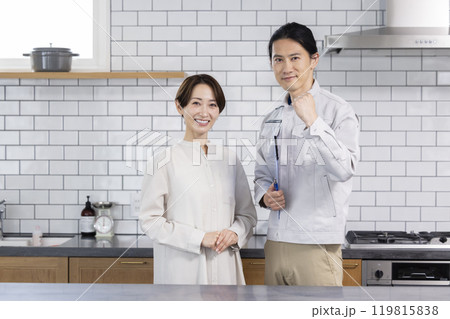 住宅営業　リフォームの相談をする主婦と作業着を着た男性 119815838