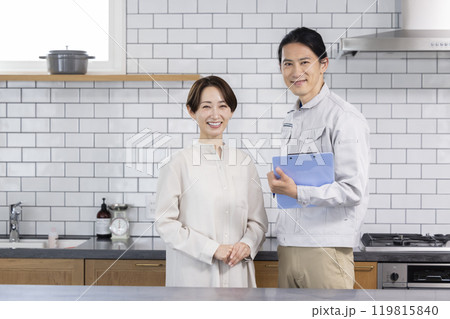 住宅営業　リフォームの相談をする主婦と作業着を着た男性 119815840