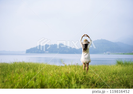 Portrait Asian Woman relaxing in green park. Happy Relax asian woman smiling face at outdoors garden. Young women enjoy nature freedom lifestyle. Greenery wellbeing outside beauty in nature. 119816452