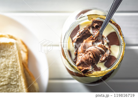 Chocolate cream spread on spoon in jar. Top view. Chocolate cream spread on spoon in jar. Top view. 119816719
