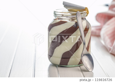 Chocolate cream spread in jar on white table. Chocolate cream spread in jar on white table. 119816726
