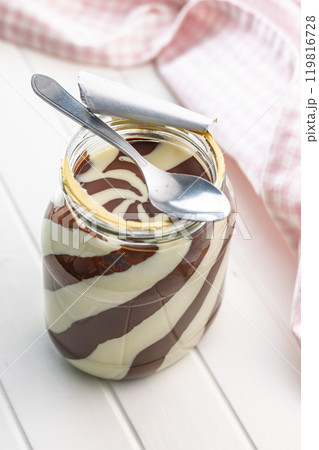 Chocolate cream spread in jar on white table. Chocolate cream spread in jar on white table. 119816728
