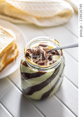 Chocolate cream spread on spoon in jar. Chocolate cream spread on spoon in jar. 119816740