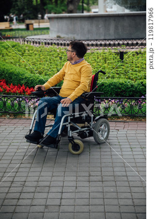 Man sitting in a wheelchair on a walk in the city Man sitting in a wheelchair on a walk in the city 119817966