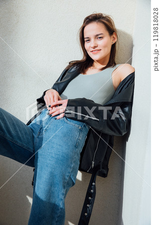 Portrait of a beautiful fashionable slender woman in jeans and a black jacket Portrait of a beautiful fashionable slender woman in jeans and a black jacket 119818028