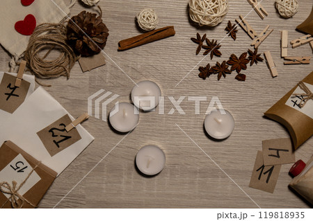 Unrecognizable young woman paint numbers on tea candles. Female making homemade advent calendar Made with your own hands step by step DIY crafts do it yourself. Preparation to christmas concept 119818935