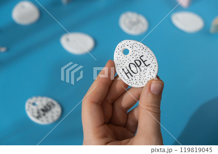 Workshop writing word HOPE on EASTER clay egg Creator is using white air dry clay for making decor to EASTER holiday. Creating hobby recreation activity that involves fingers. DIY crafting 119819045