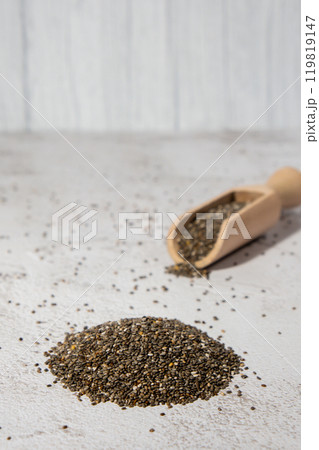 Heap of Chia seeds with wooden spoon. Healthy superfood rich in Omega 3 fatty acids. Dry healthy natural ingredient. Chia grains are falling 119819147